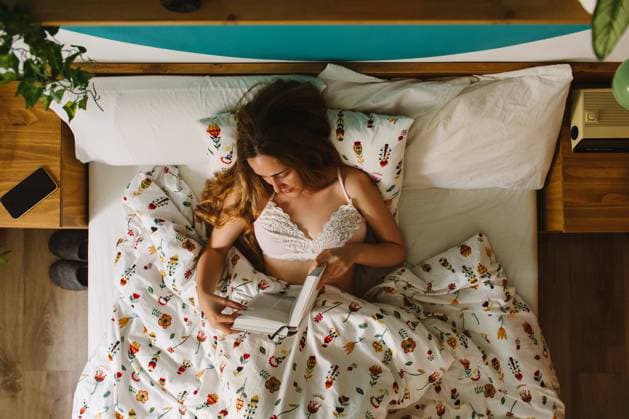 IMAGO Creative, Lifestyle, Tik Tok-Trend thatgirl From above of young female lying down in comfortable bed and reading book in morning Copyright: xLightsyx Model Released