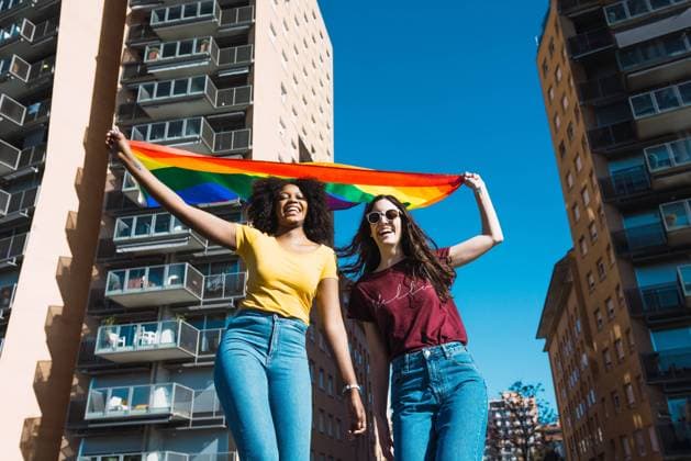 IMAGO Creative: Pride Month 2022, Engagement der Jugendlichen Lesbian couple celebrating with LGBT flag on gay pride day Copyright: xLuisxMarioxHernandezx Model Released