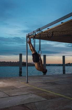 IMAGO Creative, Jahreszeit Sommer, Sommer in der Stadt Athletic man balancing on gymnastic rings, Model released Copyright: xLuisxMarioxHernandezx MR