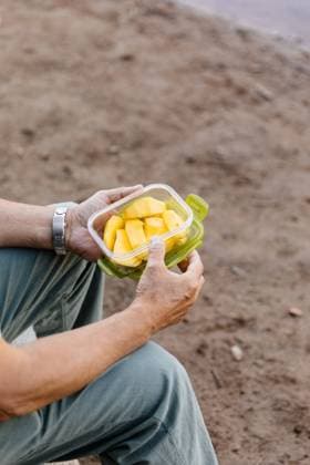 Detail of unrecognizable man eating mango fruit in the forest, Model released Copyright: xMarcosxOsoriox MR