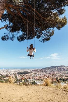 IMAGO Creative, Lifestyle, Frühling in der Stadt Blonde girl swinging with city view in background, Model released Copyright: xMarcosxOsoriox MR