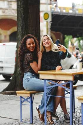 IMAGO Creative, Fr?hling, Start der Stra?encafe-Saison beautiful young women sitting in Berlin street cafe taking selfie, Model released Copyright: xMiguelxVallsx MR