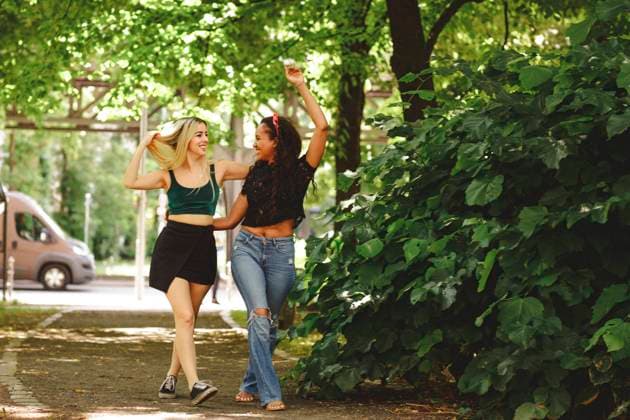 IMAGO Creative: Sommer, Sommertage im Stadtpark Cheerful women walking on green summer street in Berlin on sunny day, Model released Copyright: xMiguelxVallsx MR
