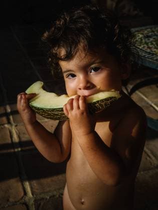 cute little girl eating melon outside at sunset Copyright: xPatriciaxBecarotox Model Released