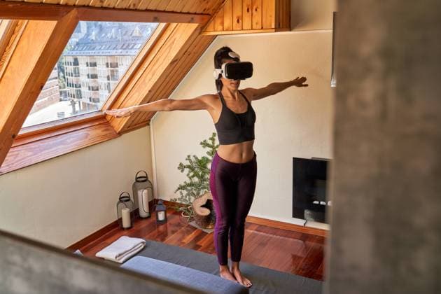 IMAGO Creative: Sport Start-Up Full body barefoot lady in VR glasses standing in Mountain pose with clasped hands while doing yoga in morning at home Copyright: xPhilippexDegrootex Model Released