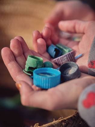 IMAGO Creative: Zivildienst und ehrenamtliches Engagement From above crop hands of teenager with pile of little plastic garbage near container on ground Copyright: xPhilippexDegrootex Model Released