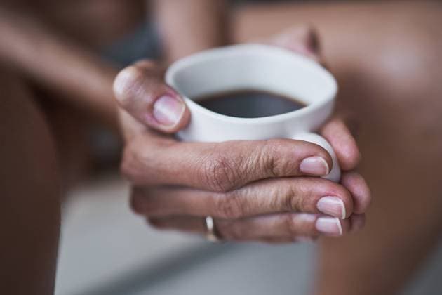 Cropped unrecognizable woman holding cup of black coffee at home Copyright: xPhilippexDegrootex Model Released