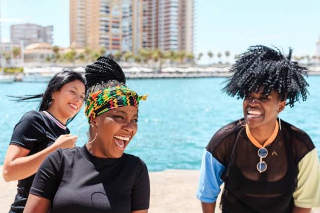 IMAGO Creative, Jahreszeit Sommer, Sommer in der Stadt IMAGO Creative: Urban Diversity Company of diverse female friends laughing during city stroll near waterside in summer, Model released Copyright: xPicuaxEstudiox MR