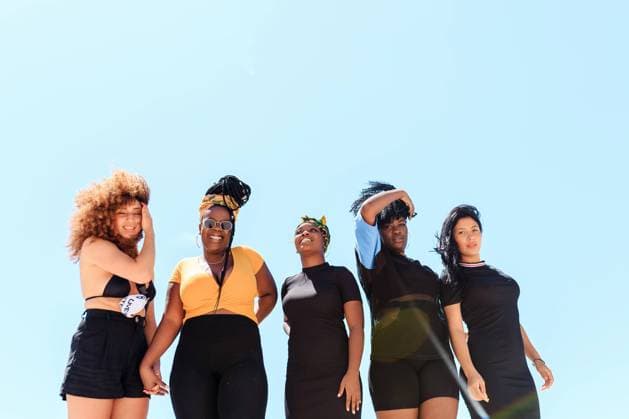 IMAGO Creative: Urban Diversity Company of diverse female friends laughing during city stroll near waterside in summer, Model released Copyright: xPicuaxEstudiox MR