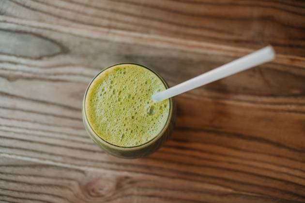 From above bubble frothy tasty fragrant green smoothie in glass on wooden table, Model released Copyright: xSoniaxAlmudevarx MR