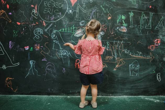 IMAGO Creative: Bildung, Schreiben Back view of unrecognizable adorable child drawing at school during class in a writing green board, Model released Copyright: xSoniaxAlmudevarx MR