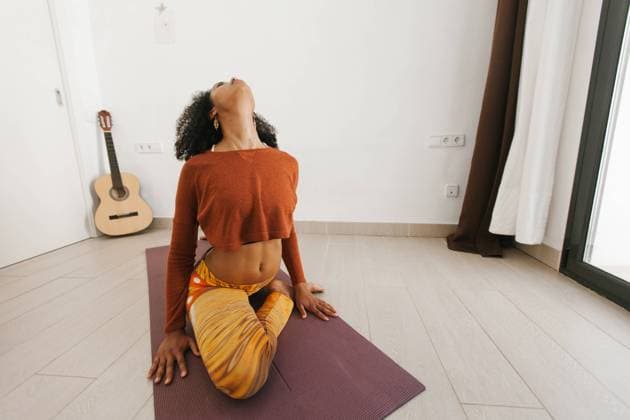 IMAGO Creative: Clickbait, Sport und Fitness African American attractive young woman sitting in yoga pose with closed eyes on mat in light room, Model released Copyright: xTadeuxDreyerx MR