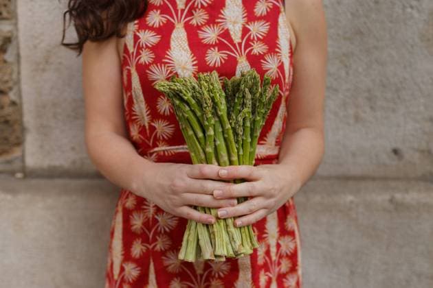 Unrecognizable cropped female with bunch of fresh asparagus on background of stone wall in city Copyright: xValeriaxSchettinox Model Released