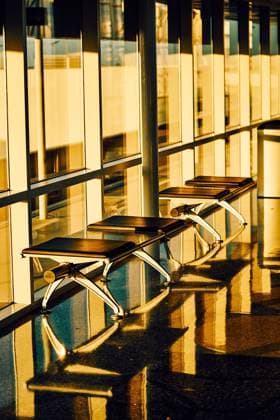 Metal bench with leather black seats along glass wall in sunny hallway of airport in Texas Copyright: xVictorxBorderax Model Released