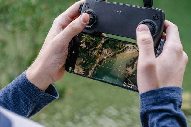 IMAGO Creative: Klimawandel - Zukunft und Innovation Unrecognizable male with remote controller operating unmanned drone and recording video of spectacular landscape Copyright: xVictorxGonzalezx Model Released