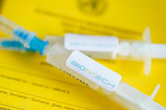 Symbolfoto Impfspritze Biontech und Impfpass Symbolfoto einer BIONTECH Impfspritze auf einem Impfpass. Der Biontech Impfstoff steht vor der Eil Zulassung und Freigabe der europaeischen Arzneimittelagentur EMA zur Impfung der ersten Risikogrupppen gegen das Corona Virus Deutschland