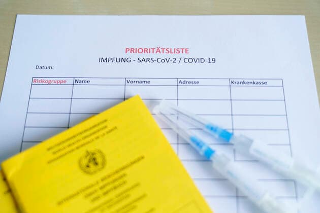 Symbolfoto Impfspritze Biontech und Impfpass Symbolfoto einer Warteliste und Prioritaetsliste von Risikogruppen zur Impfung mit einer BIONTECH Impfspritze und Impfpass. Deutschland