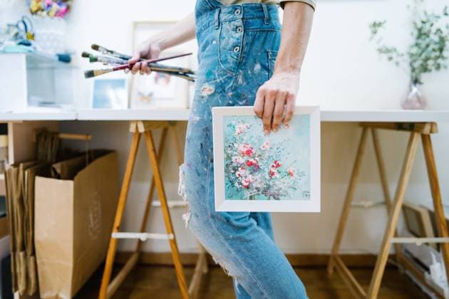 IMAGO Creative: Digitale Welt, Verzicht auf Technologie Side view of anonymous female artist standing near easel and holding a colorful paint and brushes in creative workshop Copyright: xVictorxGonzalezx Model Released