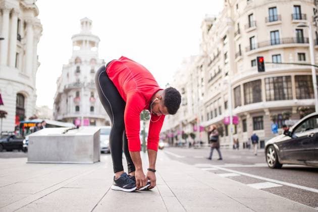 Young man stretching legs in the street Copyright: xWidetapex Model Released