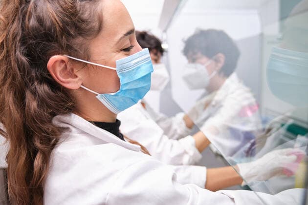 Two young female scientists wearing face masks during an experiment in a laminar flow hood. Laboratory research concept. Madrid, Community of Madrid, Spain CR_CRVI201216-591534-01 ,model released, Symbolfoto