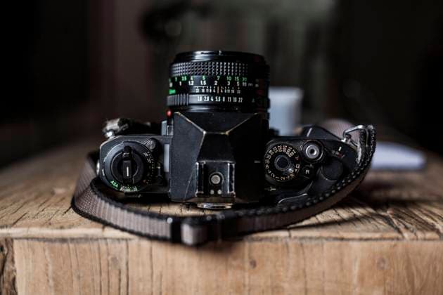 scene with analog camera, film reels, on old wooden table. Copyright: xDavidxFuentesx Model Released
