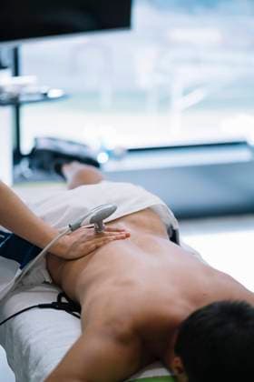 IMAGO Creative: NGO, Rehabilitation und Gesundheitswesen The physiotherapist treating a man using equipment for radio therapy Copyright: xx Model Released
