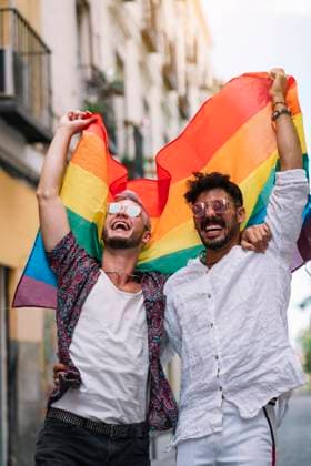 Couple boys with gay pride flag on the street of Madrid city Copyright: xJosexLuisxCarrascosax Model Released