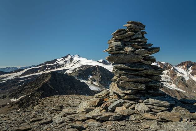 Stacked stones on Hintere Schoentaufspitze (Punta Beltovo di Dentro, South Tyrol, Italy) on a sunny day in summer Stilfs Italy