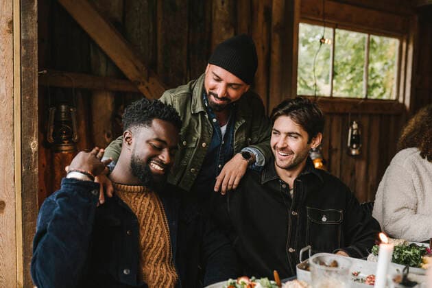 Smiling man talking to male friends at dinner party Sweden, Stockholm, model released, property released Copyright: xMaskotx , MA83209