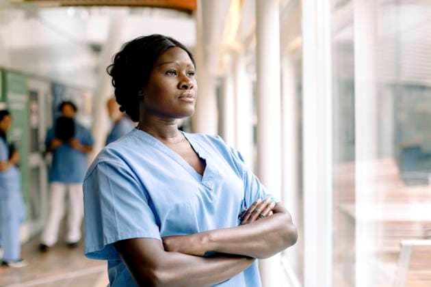 IMAGO Creative: Internationaler Frauentag, Gender Pay Gap, Frauen verdienen 18 Prozent weniger Contemplating female nurse with arms crossed looking through window in hospital Sweden, Stockholm, model released, property released Copyright: xMaskotx , MA83350