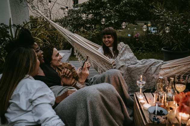 IMAGO Creative: Landleben - Essen Smiling woman on hammock with friends enjoying during social gathering Sweden, Stockholm, model released, property released Copyright: xMaskotx , MA83384