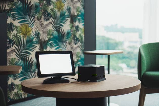 Blank monitor and small system unit of modern PC standing on lumber round table in stylish room in Singapore Copyright: xKikexArnaizx Model Released