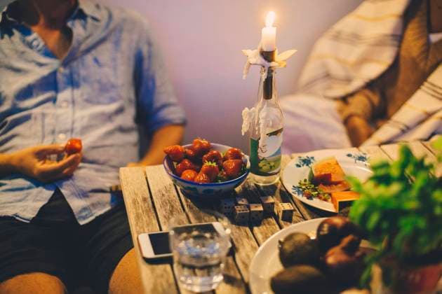 Midsection of couple having fruits during candlelight dinner in houseboat Sweden, Stockholm, model released, property released Copyright: xMaskotx , MA83499