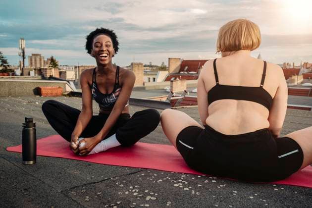 Cheerful woman with female friend exercising on rooftop Germany, Berlin, model released, property released Copyright: xMaskotx , MA83564