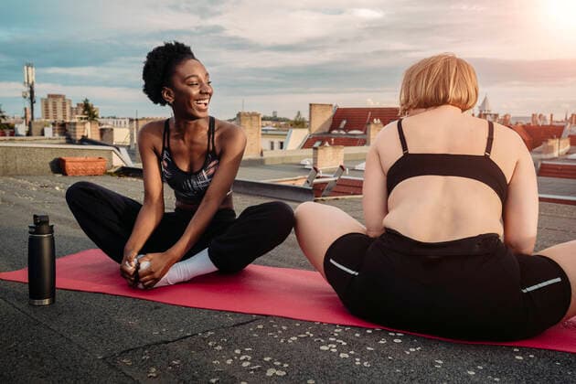 Smiling female friends exercising on rooftop Germany, Berlin, model released, property released Copyright: xMaskotx , MA83588