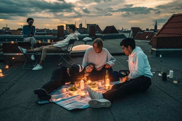 Male and female friends talking on building terrace during sunset Germany, Berlin, model released, property released Copyright: xMaskotx , MA83591
