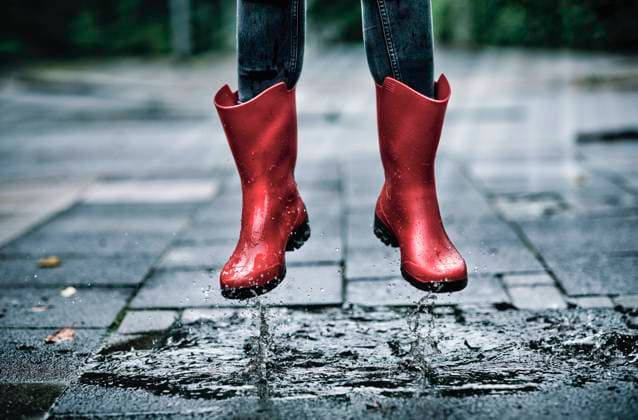 Feet of little girl wearing rubber boots jumping over small puddle model released Symbolfoto FLLF00518