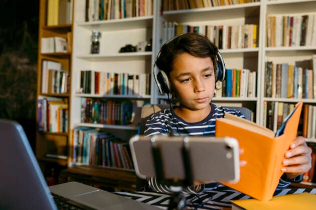 Boy holding book while vlogging at home model released Symbolfoto property released VABF04067