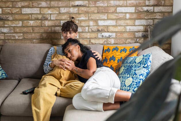 Woman leaning on pregnant girlfriend stomach while sitting at home model released Symbolfoto WPEF03604