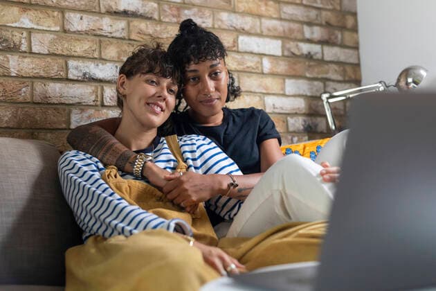Young lesbian couple watching laptop while sitting on sofa at home model released Symbolfoto  WPEF03617