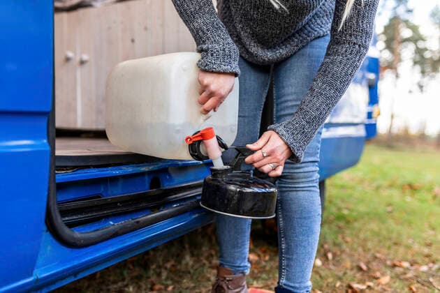 IMAGO Creative: Klimawandel - Nachhaltiges Reisen Mid adult woman pouring water in camping teapot model released Symbolfoto  WPEF03783