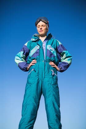 IMAGO Creative: Wintersport, Mode Woman wearing ski suit with closed eyes Woman wearing ski suit with closed eyes and hands on hips, model released 