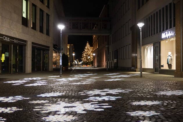am 27.12.2020 in Karlsruhe (Innenstadt), Germany Leere Straßen nach der Sperrstunde 20 Uhr zur Ausgangsbeschränkung einen Tag nach Weihnachten. Eine Beleuchtung projiziert Schneeflocken auf den Boden. Karlsruhe Innenstadt Baden-Württemberg Germany