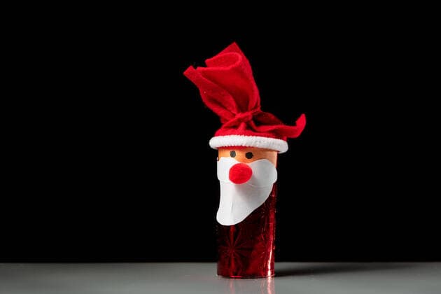 A figure of Santa Claus made of a toilet paper roll by a child, black background Floridsdorf Austria