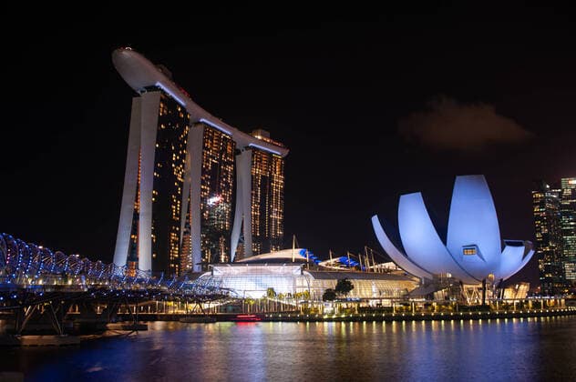 12.03.2020, Singapur, Republik Singapur, Asien - Blick ueber Marina Bay auf das beleuchtete Luxushotel Marina Bay Sands und dem ArtScience Museum waehrend der weltweiten Corona-Pandemie. Das architektonische Wahrzeichen feiert dieses Jahr sein zehnjaehriges Jubilaeum seit seiner Eroeffnung im Jahr 2010. *** 12 03 2020, Singapore, Republic of Singapore, Asia View across Marina Bay to the illuminated luxury hotel Marina Bay Sands and the ArtScience Museum during the global corona pandemic The architectural landmark celebrates its tenth anniversary this year since its opening in 2010