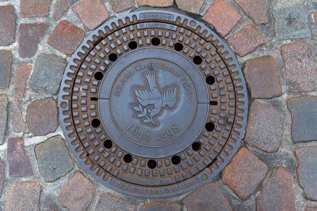 Kanaldeckel mit dem Symbol einer Friedenstaube zum 350 Jahrestag Westfälischer Frieden, Münster, Nordrhein-Westfalen, Deutschland, Europa *** Manhole cover with the symbol of a peace dove for the 350th anniversary of the Peace of Westphalia, Münster, North Rhine-Westphalia, Germany, Europe Copyright: imageBROKER HelmutxMeyerxzurxCapellen ibxmzc05955860.jpg