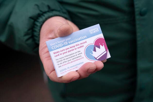 (210107) -- GREATER MANCHESTER, Jan. 7, 2021 -- A member of staff holds vaccination record cards given to members of the public receiving their second dose of the Pfizer-BioNTech COVID-19 vaccine at Hyde Leisure Centre in Greater Manchester, Britain, on Jan. 7, 2021. British Prime Minister Boris Johnson told MPs on Wednesday that the government will use every available second of the lockdown to place an invisible shield around elderly and vulnerable people through the rollout of COVID-19 vaccines in the coming weeks. (Photo by Xinhua) BRITAIN-GREATER MANCHESTER-COVID-19-VACCINE JonxSuper 