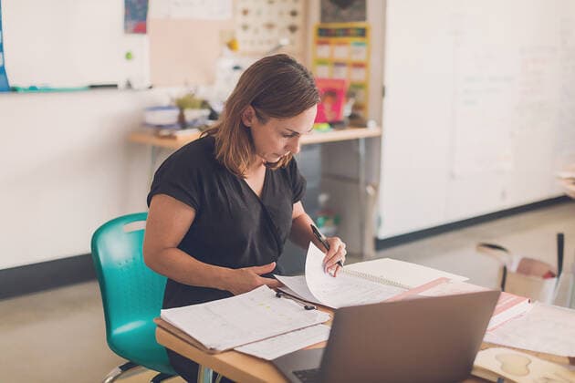 Elementary school teacher organizing papers in her classroom. San Diego, CA, United States CR_CHDO210108-535001-01 ,model released, Symbolfoto