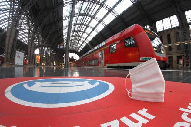 Getragene Mund-Nase-Maske liegt auf dem Bahnsteig vor einem Regionalexpress der DB Deutsche Bahn im Hauptbahnhof Frankfurt, Hessen, Deutschland