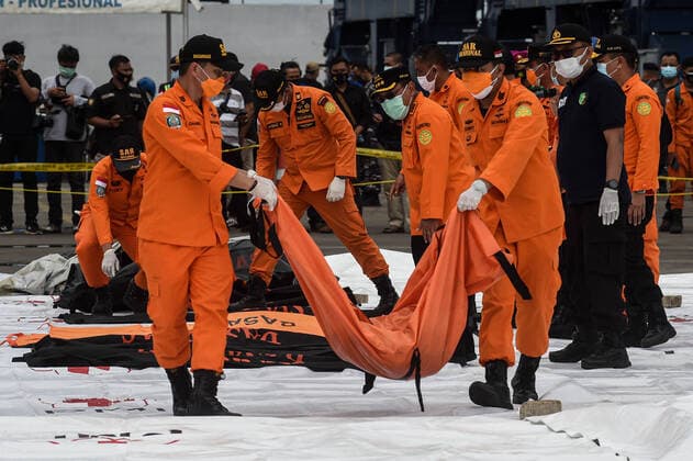 Bilder des Jahres 2021, News 01 Januar News Themen der Woche KW01 News Bilder des Tages (210110) -- JAKARTA, Jan. 10, 2021 -- Members of the Indonesian Search and Rescue (SAR) team carry body parts of passengers on board the Sriwijaya Air flight SJ-182 at Tanjung Priok Port, Jakarta, Indonesia, Jan. 10, 2021. Rescuers on Sunday collected five bags of human body parts and three bags of debris of the Sriwijaya Air plane that crashed in the waters off the coast of Indonesian capital Jakarta, a senior official said. (Photo by Xinhua) INDONESIA-JAKARTA-PLANE CRASH-SEARCH AgungxKuncahyaxB. 